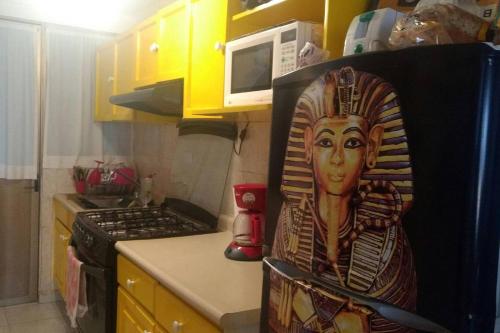 een keuken met een schilderij van een vrouw op het fornuis bij Style House in Cancun in Cancun