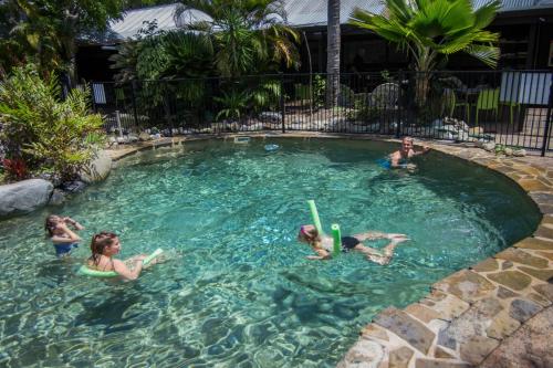 a group of people playing in a swimming pool at Coral Beach in Port Douglas