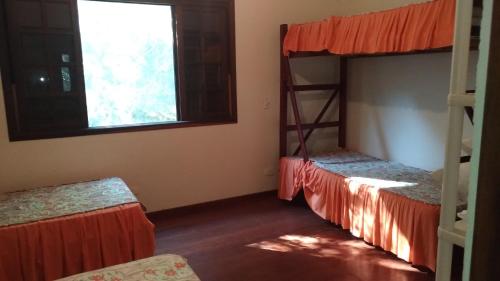 ein Zimmer mit zwei Etagenbetten und einem Fenster in der Unterkunft Casa Bela da ilha II in Ilhabela