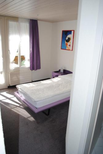 a bed in a room with a window at Hotel Châlet Du Lac in Iseltwald