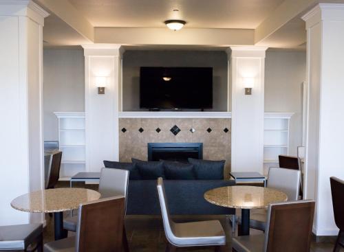 a living room with two tables and a couch at Wingate by Wyndham Moses Lake in Moses Lake