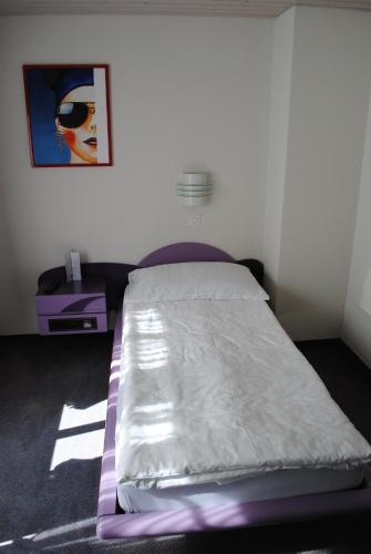 a bed in a room with a purple bed frame at Hotel Châlet Du Lac in Iseltwald