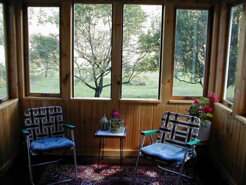 two chairs and a table in a room with windows at Mountain Valley Retreat in Killington