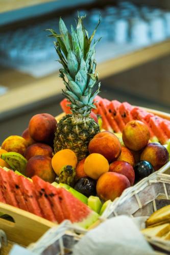 un ananas appoggiato sopra un cesto di frutta di Aqua Oliva Resort Syvota a Sivota