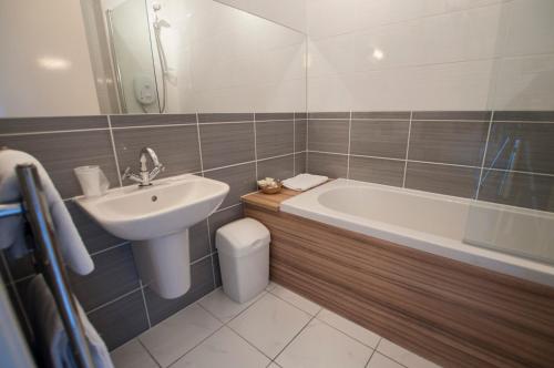 a bathroom with a sink and a tub and a toilet at The Mey Hotel in Mey
