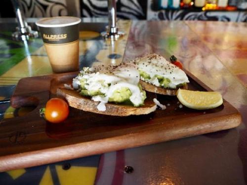 a sandwich on a cutting board with a lemon and a drink at Hotel Villa Hakuba by HHG in Hakuba