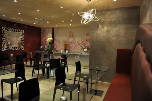 a restaurant with tables and chairs and a bar at Mercure Paris Bastille Marais in Paris