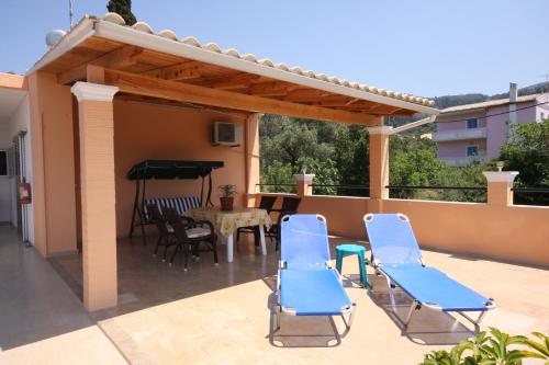 a patio with chairs and a table and a piano at Kostas Apartments & studios in Agios Georgios Pagon