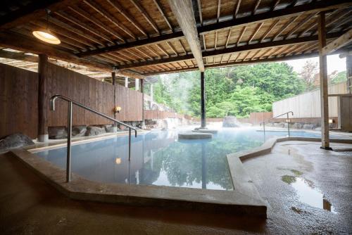 a large pool of water in a building at Yufuin Onsen Tsukanoma in Yufuin