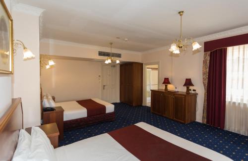 a hotel room with two beds and a mirror at Palais Royale in Katoomba
