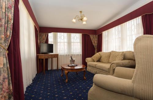 a living room with a couch and a tv at Palais Royale in Katoomba