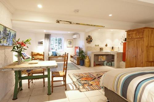 a bedroom with a bed and a table and a living room at kookaburra Down Under Coogee Beach in Sydney