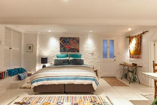 a bedroom with a large bed with blue pillows at kookaburra Down Under Coogee Beach in Sydney