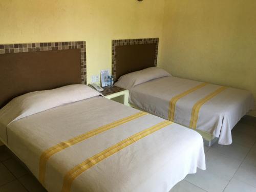 a room with two beds in a room at Hotel Maria Mixteca in Santa Cruz Huatulco