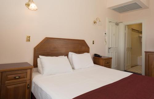 a bedroom with a large bed with a wooden headboard at Palais Royale in Katoomba