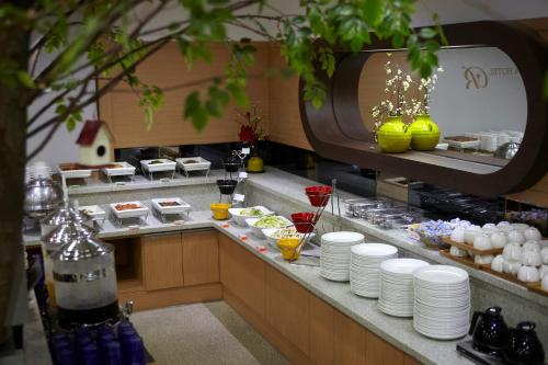 a buffet line with plates and dishes on a counter at Benikea Hotel Yeosu in Yeosu