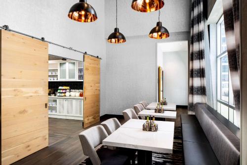 a dining room with tables and chairs and lights at Hyatt Place Long Island City in Queens