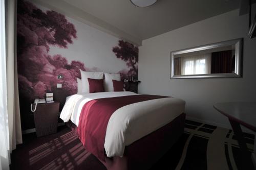 a bedroom with a large bed with a red blanket at Mercure Paris Bastille Marais in Paris