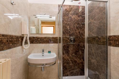 a bathroom with a shower, sink, and toilet at Hearth Hotel in Rome