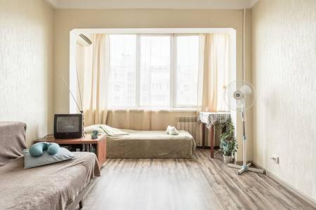 a living room with a couch and a window at Comfortable Apartment on the River Bank in Kyiv