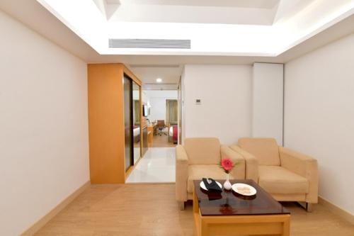 a living room with two chairs and a table at The Central Residency in Trivandrum