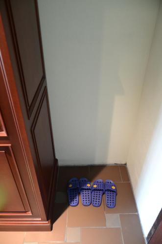 a row of blue shoes in the corner of a room at Saksiri Riverside Boutique Hotel in Vang Vieng