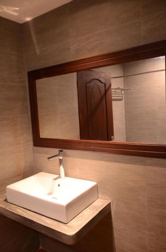 a bathroom with a sink and a mirror at Saksiri Riverside Boutique Hotel in Vang Vieng