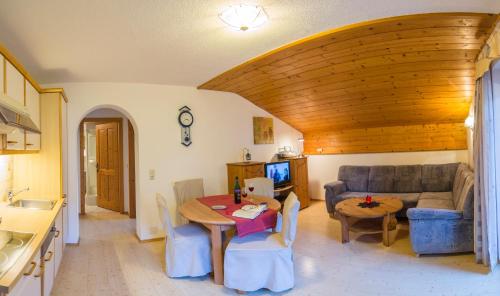 a living room with a table and a couch at BergQuell in Tannheim