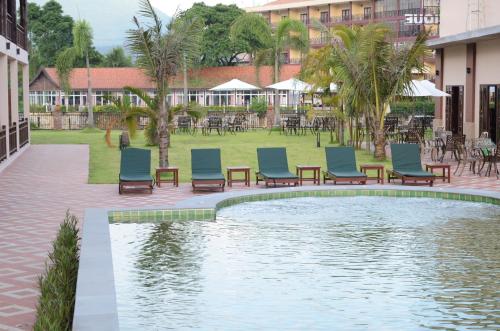 a pool with chairs and tables in a courtyard at Saksiri Riverside Boutique Hotel in Vang Vieng