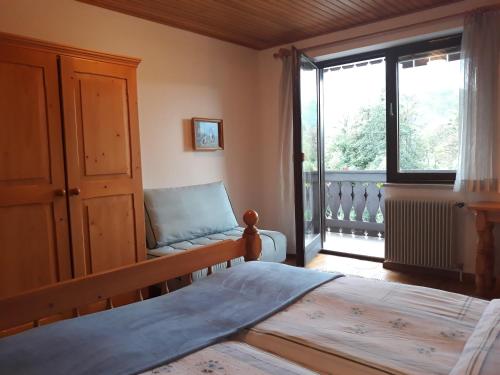 een slaapkamer met een bed en een groot raam bij Turistična kmetija Žerovc in Bled