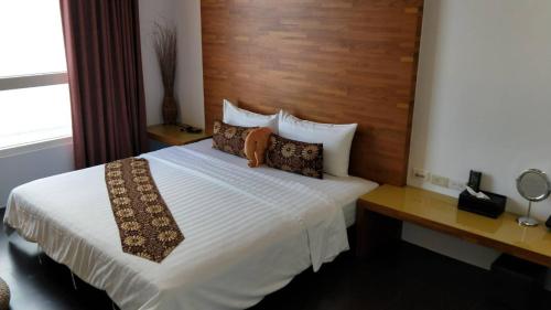 una camera da letto con un letto bianco con testiera in legno di HI One One a Magong