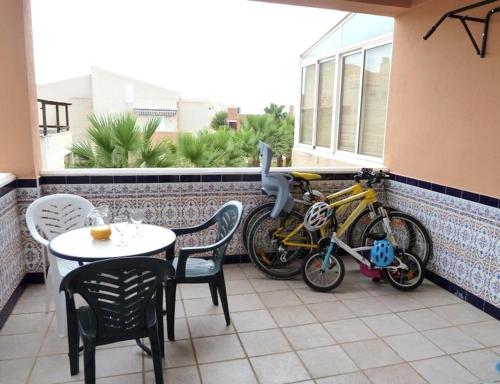 a bike parked on a balcony with a table and chairs at Duplex Naturista urb. Vera Natura in Vera