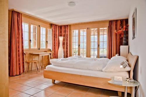 ein Schlafzimmer mit einem großen Bett in einem Zimmer mit Fenstern in der Unterkunft Chalet Heimat - GRIWA RENT AG in Grindelwald