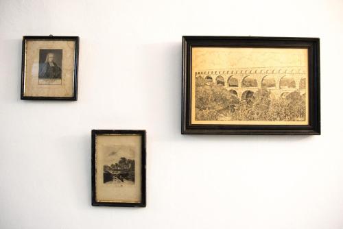 a group of framed pictures hanging on a wall at Les suites du 17 in Aigues-Mortes