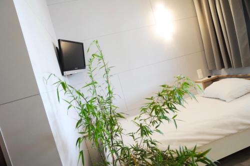 a bedroom with a bed and a tv on a wall at Totalenergies Frit Autentic Habay-la-Neuve in Habay-la-Neuve