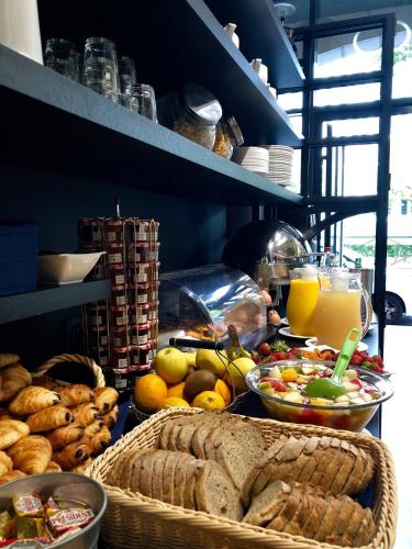 a kitchen with baskets of food and bread and orange juice at Hotel Art Deco Euralille in Lille