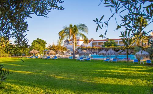 a resort with a large yard with chairs and a pool at Captain Karas Holidays Apartments in Protaras