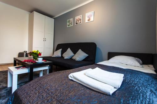 - une chambre avec un lit et une chaise dans l'établissement Batory Apartament, à Chorzów