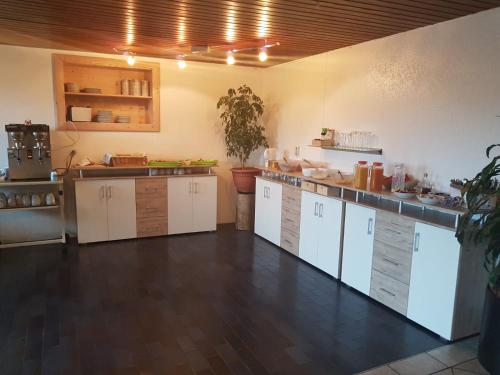 a large kitchen with white cabinets and a counter at Pension Hirsch in Lechbruck