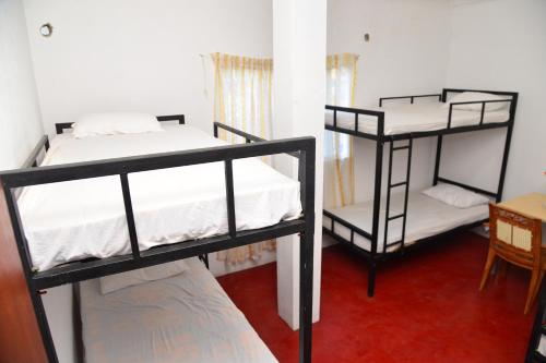 a room with two bunk beds and a table at Lucky Beach Front Hostel in Hikkaduwa