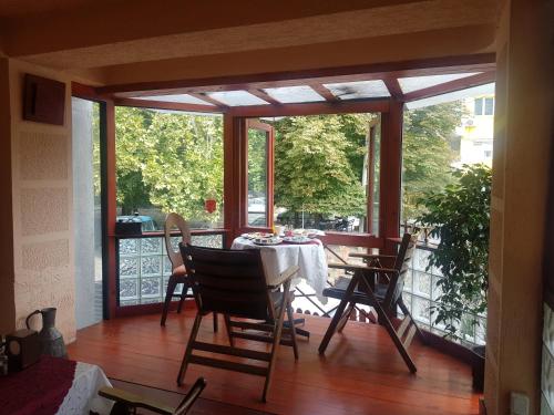 a screened in porch with a table and chairs at Hotel Kapistec Skopje in Skopje