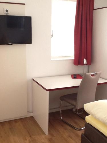 a room with a desk with a chair and a window at Hotel Adler in Babenhausen