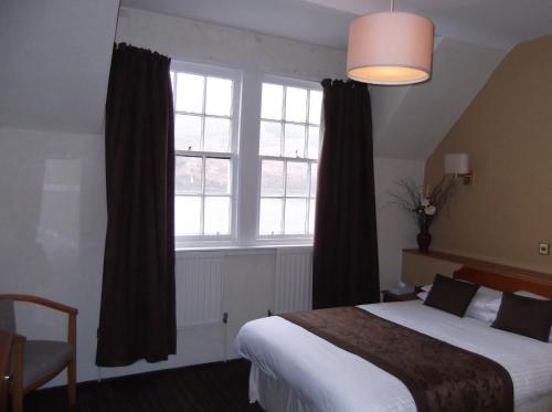 a bedroom with a bed and a large window at Arrochar Hotel 'A Bespoke Hotel' in Arrochar
