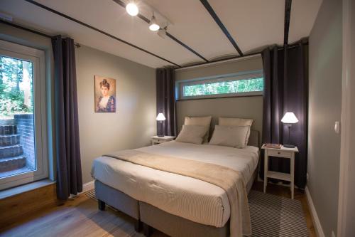 sypialnia z łóżkiem i dużym oknem w obiekcie Antonine's Atelier w mieście Hingene