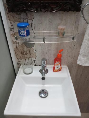 a bathroom sink with a toothbrush and a bottle of ketchup at Heavenly Homestay in Cochin