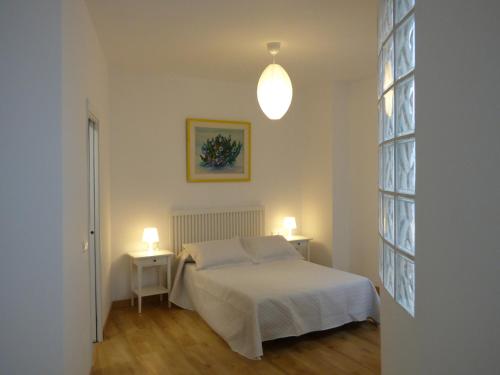 ein Schlafzimmer mit einem Bett und zwei Tischen mit Lampen in der Unterkunft Viviendas Turísticas La Merced in Ronda