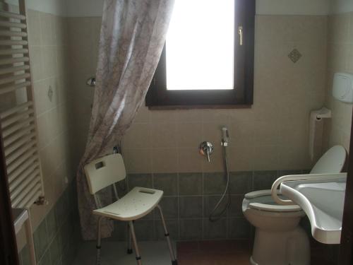 La salle de bains est pourvue de toilettes, d'un lavabo et d'une fenêtre. dans l'établissement Casale Arcadia, à Orvieto