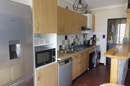 une cuisine avec des armoires en bois et un évier dans l'établissement Cures et Vacances à Amélie Les Bains, à Amélie-les-Bains-Palalda