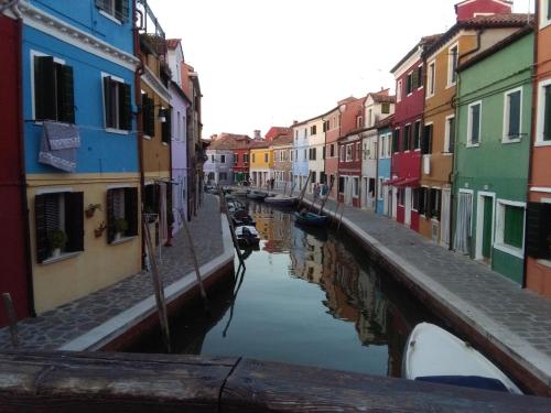 a canal in a city with colorful buildings and boats at Agriturismo Colombera in Quarto dʼAltino