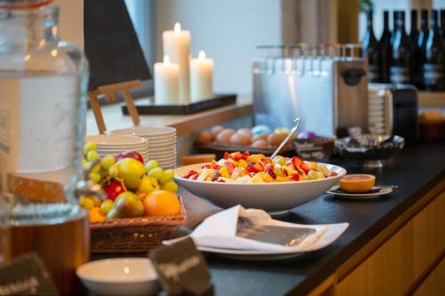 a table with bowls of fruit on a counter at B&O Parkhotel in Bad Aibling